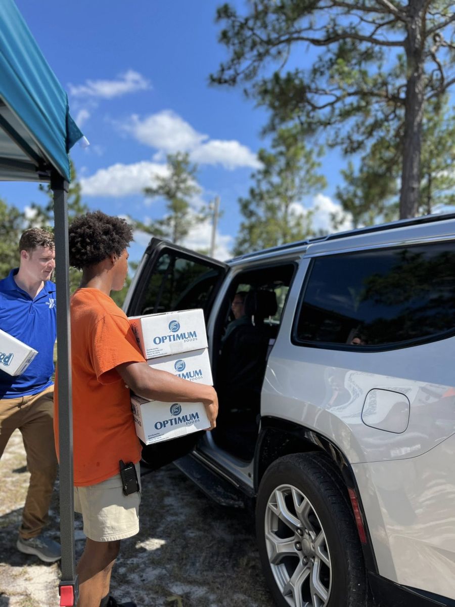Y staff and volunteers load meal boxes into cars for children through Summer Food Service Program