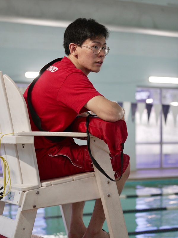 lifeguard at YMCA pool watching swimmers for safety